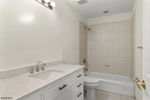 a bathroom with a granite countertop sink a toilet and shower