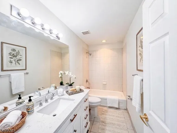 a spacious bathroom with a double vanity sink a mirror and a bathtub