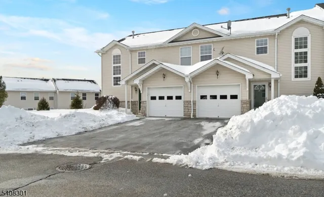 a view of a white house with a large space next to a road