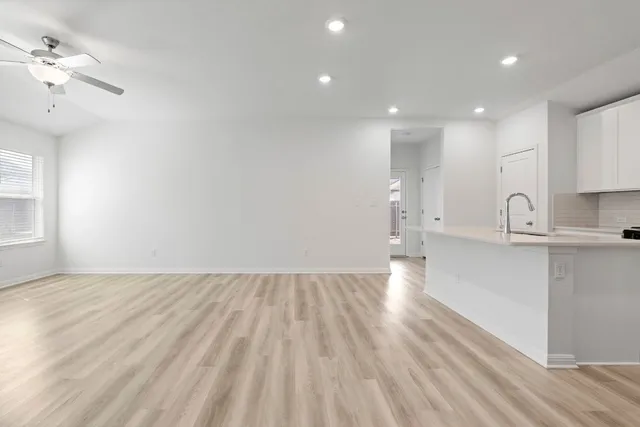 a view of a kitchen with wooden floor and a sink