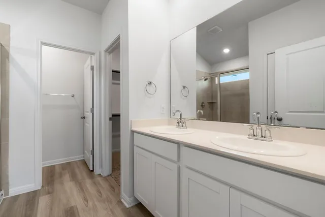 a bathroom with a sink double vanity granite tub and shower