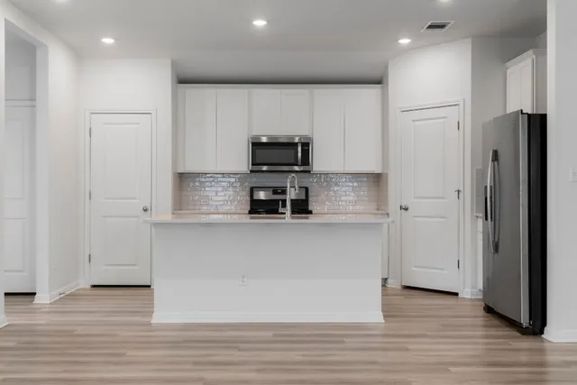 a kitchen with stainless steel appliances granite countertop a refrigerator and a stove