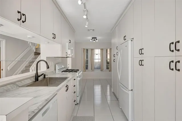 a large white kitchen with a sink