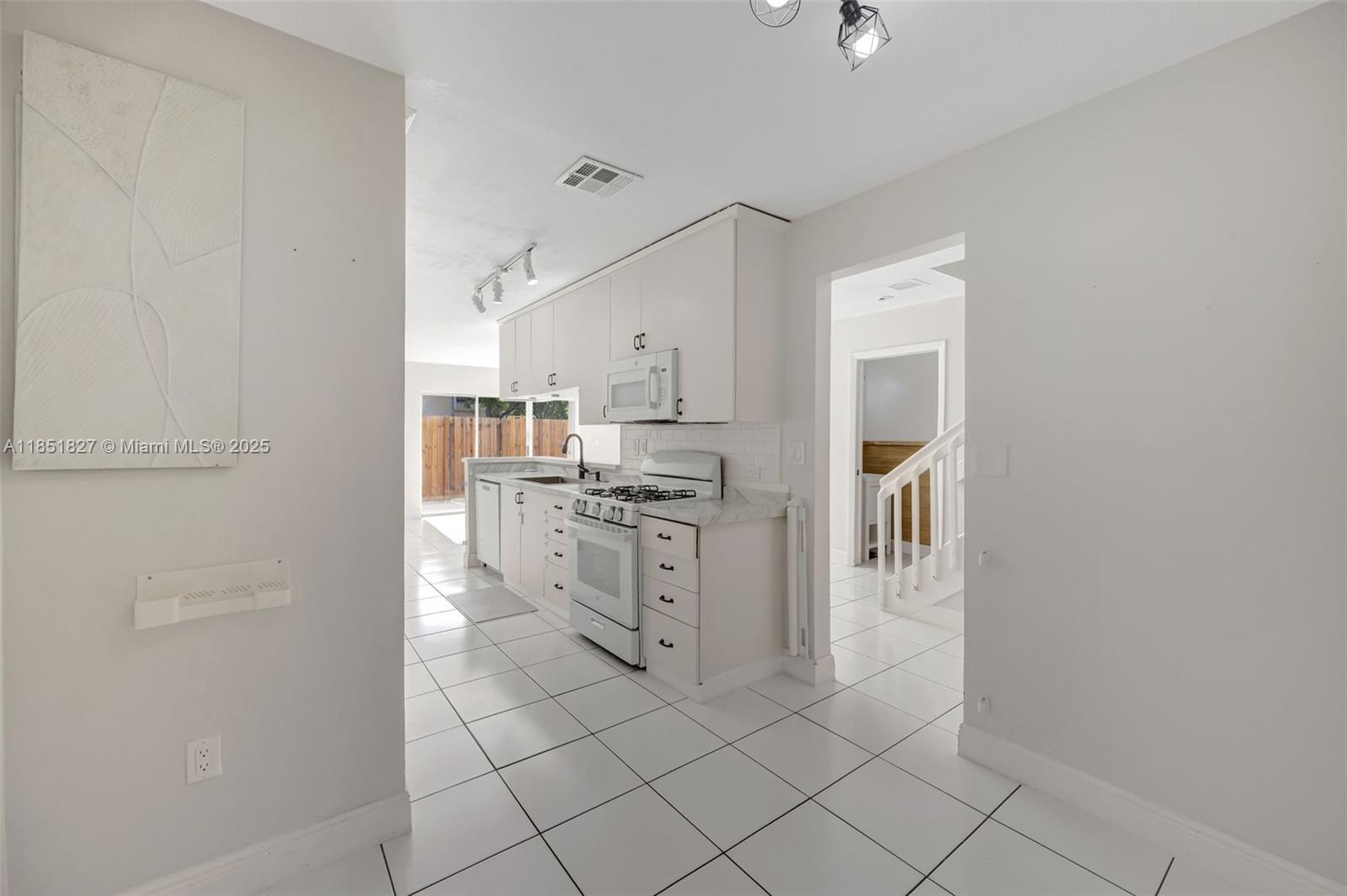 15224 Southwest 111th Street Miami, FL 33196 - Photo 14 of 27 a kitchen with white cabinets and white appliances