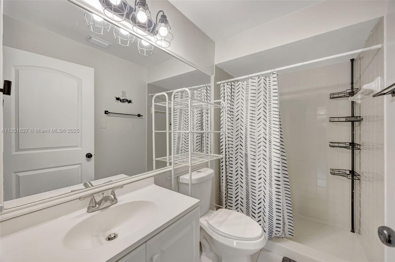 15224 Southwest 111th Street Miami, FL 33196 - Photo 25 of 27 a bathroom with a sink toilet vanity and shower