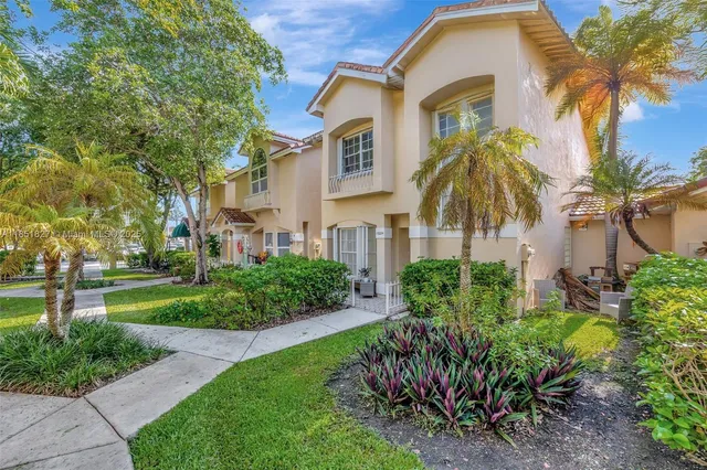 a front view of a residential houses with yard and green space