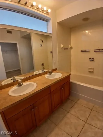 a bathroom with a granite countertop sink a mirror and a bathtub