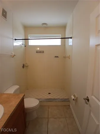 a bathroom with a granite countertop shower a toilet and a sink