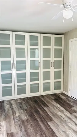 a view of an empty room with a window and a kitchen