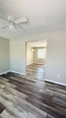 a view of empty room with window and wooden floor