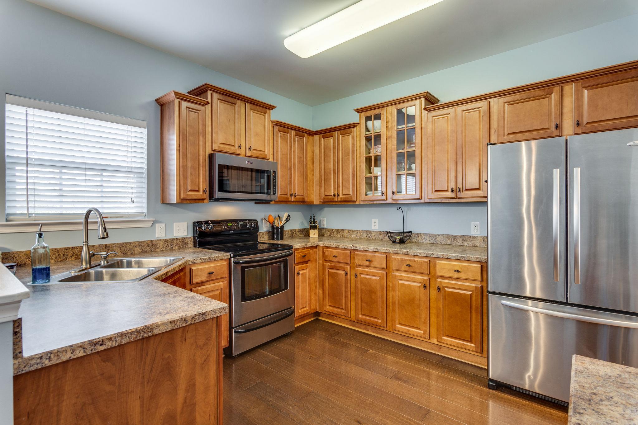 1509 Callender Road Spring Hill, TN 37174 - Photo 11 of 30 a kitchen with stainless steel appliances granite countertop a refrigerator stove microwave and sink