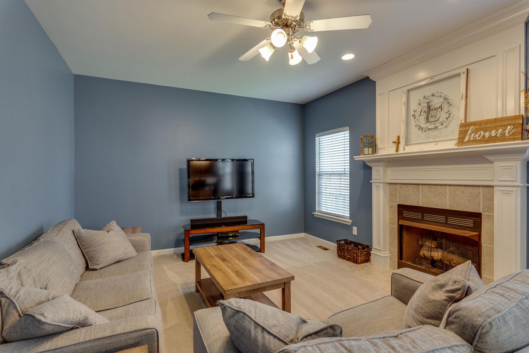 1509 Callender Road Spring Hill, TN 37174 - Photo 14 of 30 a living room with furniture a fireplace and a flat screen tv