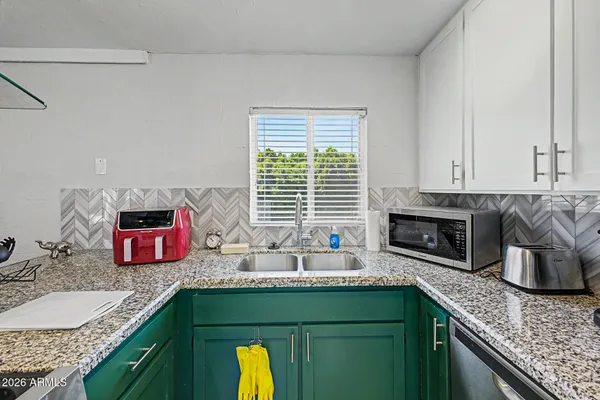 a kitchen with stainless steel appliances granite countertop a sink and a granite counter tops