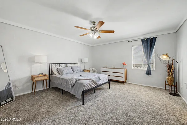 a spacious bedroom with a bed and a chandelier