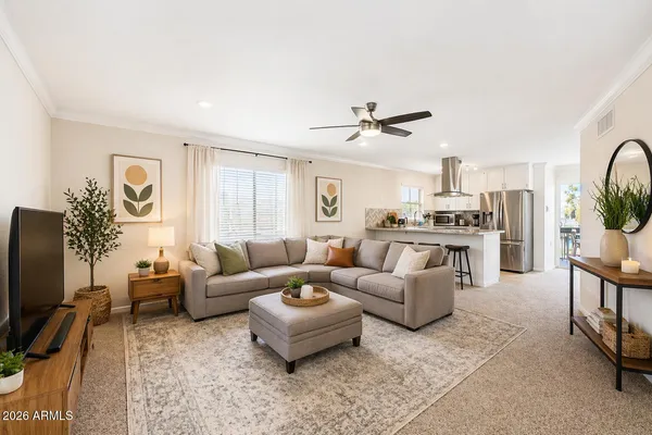a living room with furniture a flat screen tv and a window