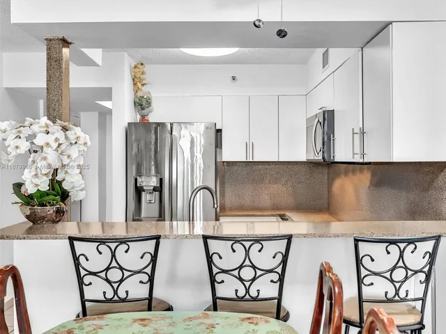 a kitchen with stainless steel appliances a table and chairs