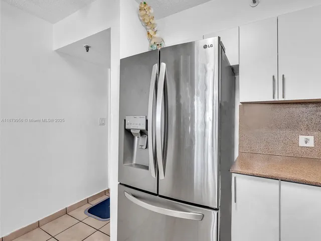 a metallic refrigerator freezer sitting in a kitchen