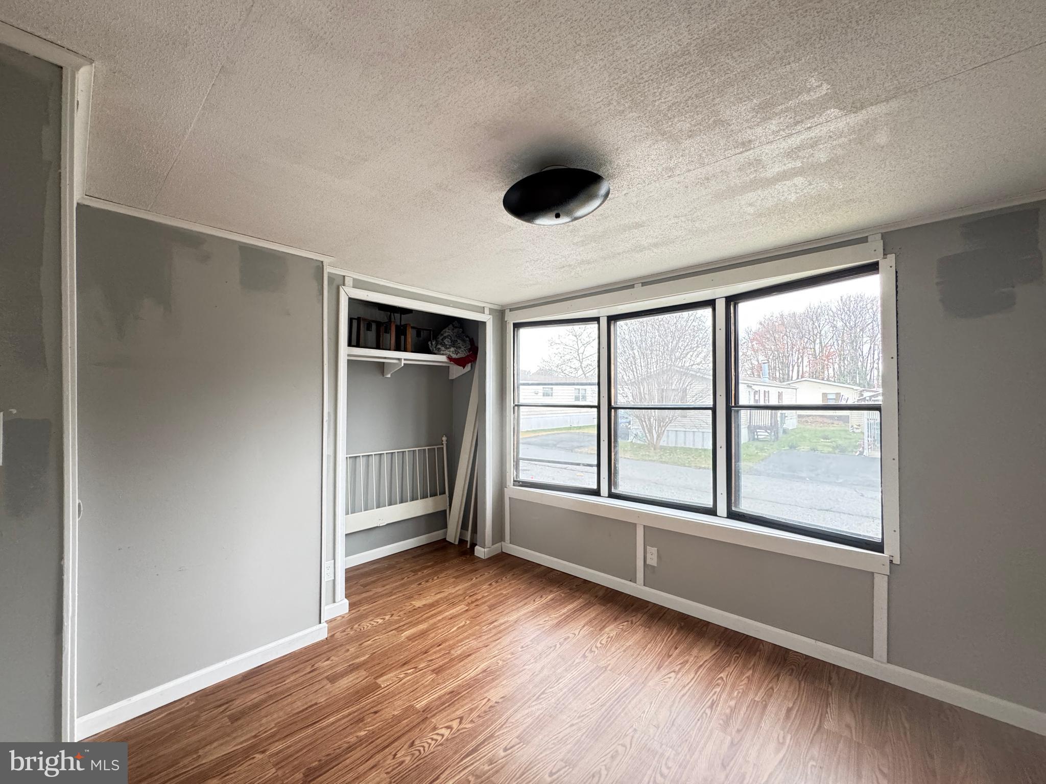 819 Leswood Court Dundalk, MD 21222 - Photo 11 of 18 a view of an empty room with wooden floor and a window