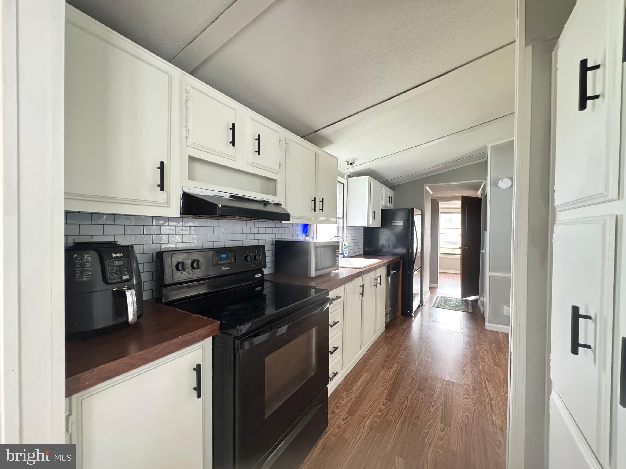 819 Leswood Court Dundalk, MD 21222 - Photo 9 of 18 a kitchen with stainless steel appliances granite countertop a stove a sink and a refrigerator