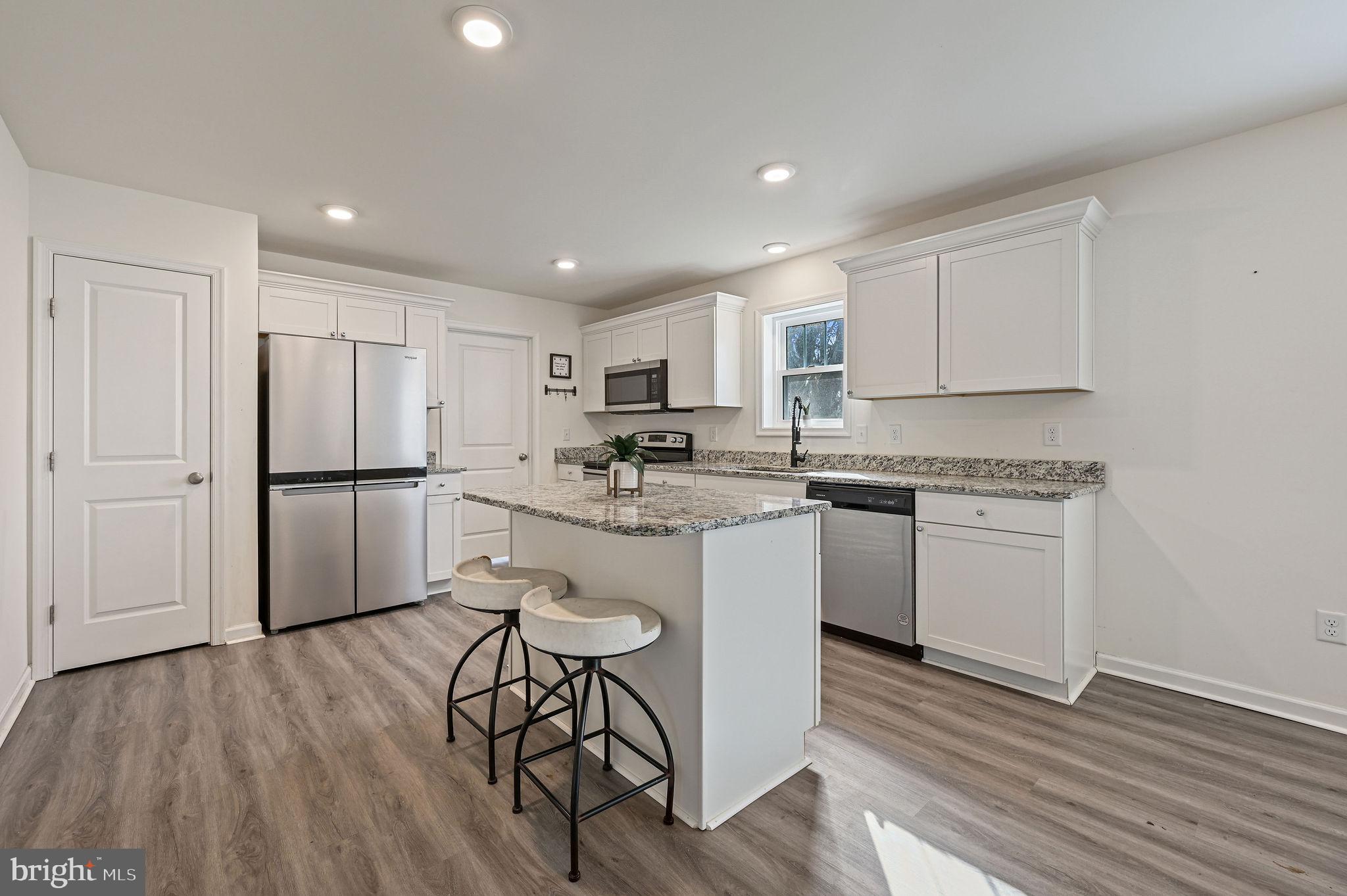 4 Senator Avenue Dover, DE 19901 - Photo 12 of 26 a kitchen with a refrigerator a white cabinets and wooden floor