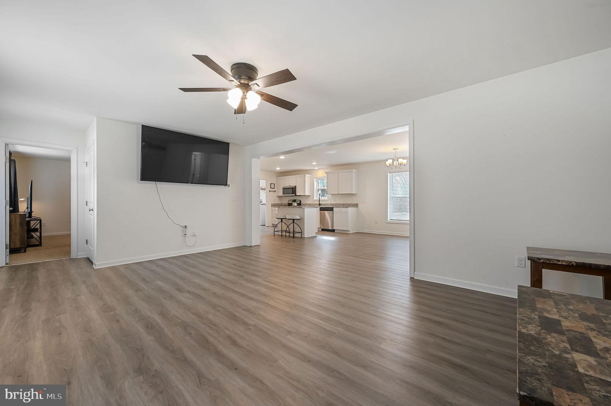 4 Senator Avenue Dover, DE 19901 - Photo 14 of 26 a view of a livingroom with a flat screen tv wooden floor and a ceiling fan