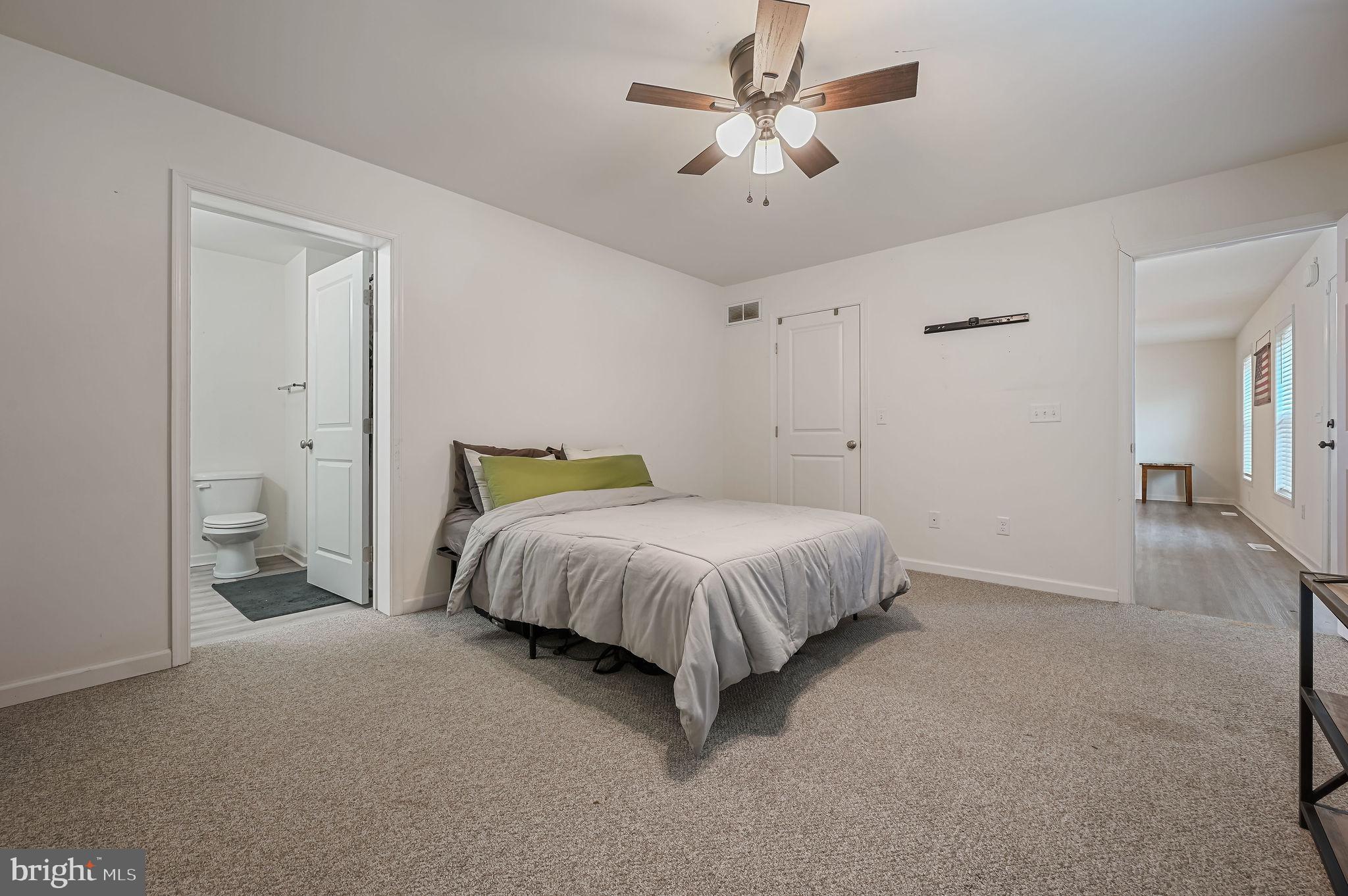 4 Senator Avenue Dover, DE 19901 - Photo 19 of 26 a spacious bedroom with a bed and a chandelier