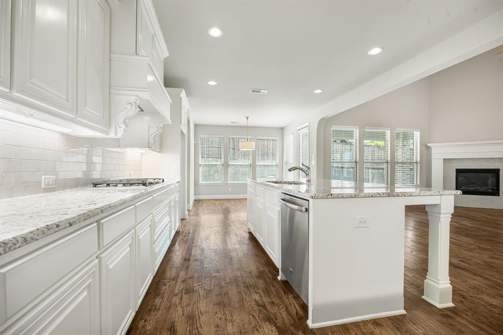1506 Mariners Hope Way Wylie, TX 75098 - Photo 13 of 39 a kitchen with granite countertop white cabinets and white appliances
