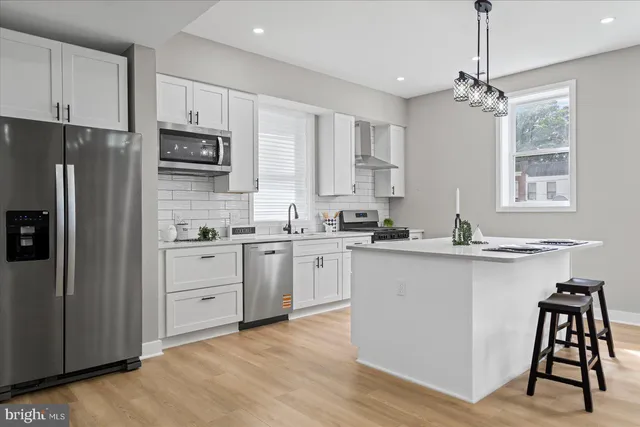 a kitchen with white cabinets and stainless steel appliances