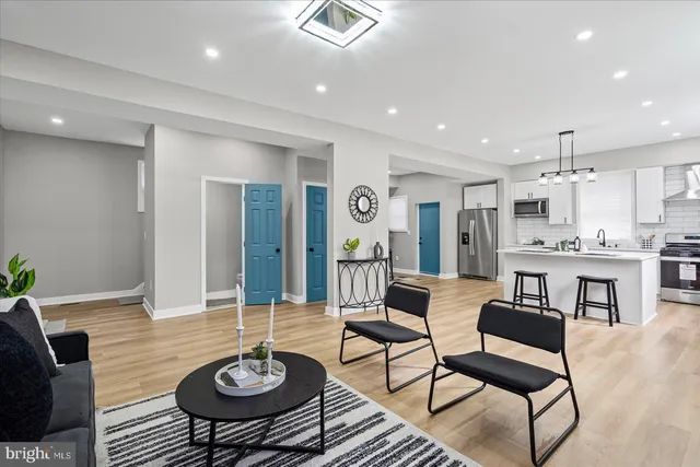 a living room with kitchen island furniture and a dining table with kitchen view