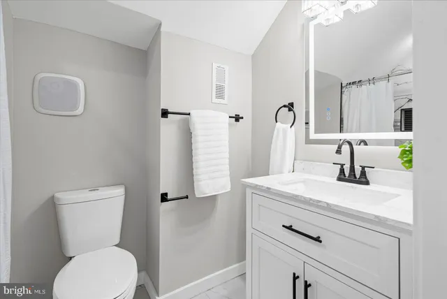 a bathroom with a sink toilet and a mirror