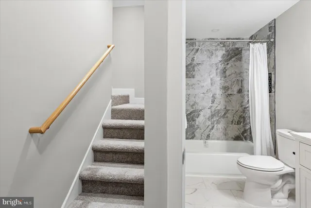 a bathroom with a toilet and a shower curtain