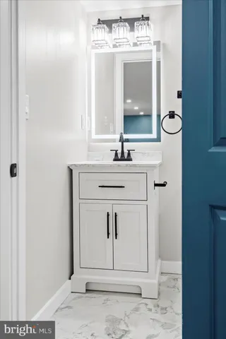 a bathroom with a sink vanity and mirror
