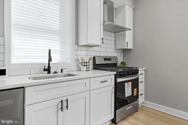 a kitchen with stainless steel appliances white cabinets and a sink