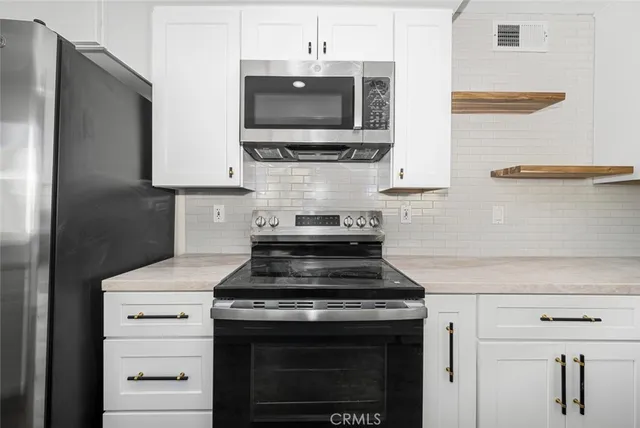 a kitchen with stainless steel appliances granite countertop a stove and a microwave