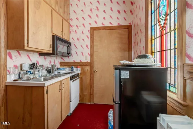 a kitchen with a refrigerator and a stove top oven