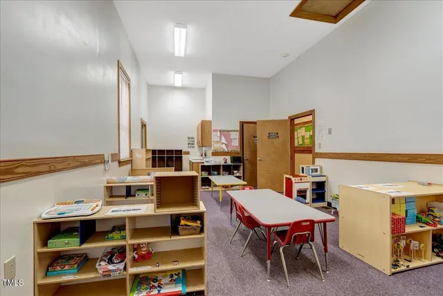 a living room with furniture a rug and a clock