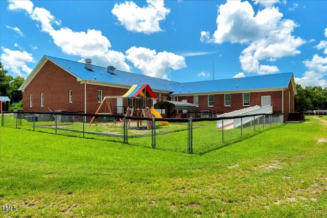 a view of a house with a backyard and a tree