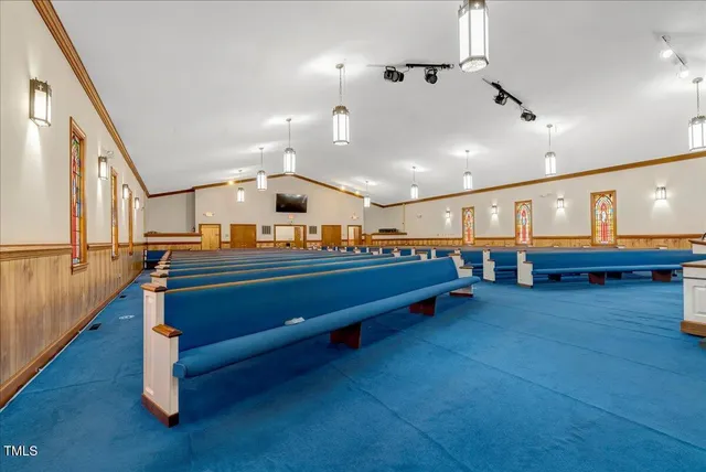 a living room with couches and kitchen view with wooden floor