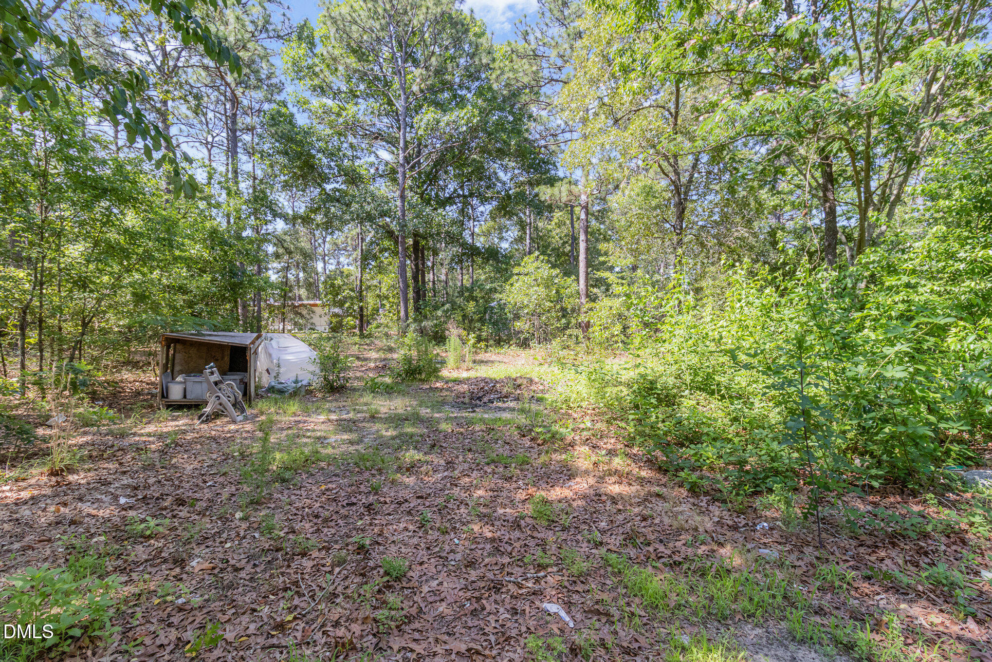 495 Horseshoe Road Aberdeen, NC 28315 - Photo 15 of 16 a backyard of a house with lots of green space and chair