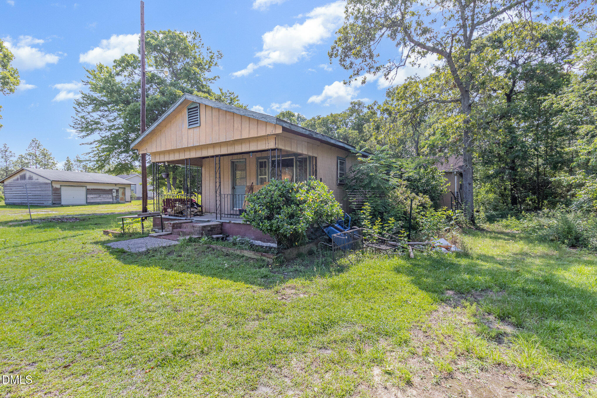 495 Horseshoe Road Aberdeen, NC 28315 - Photo 2 of 16 a view of a house with a big yard potted plants and large tree
