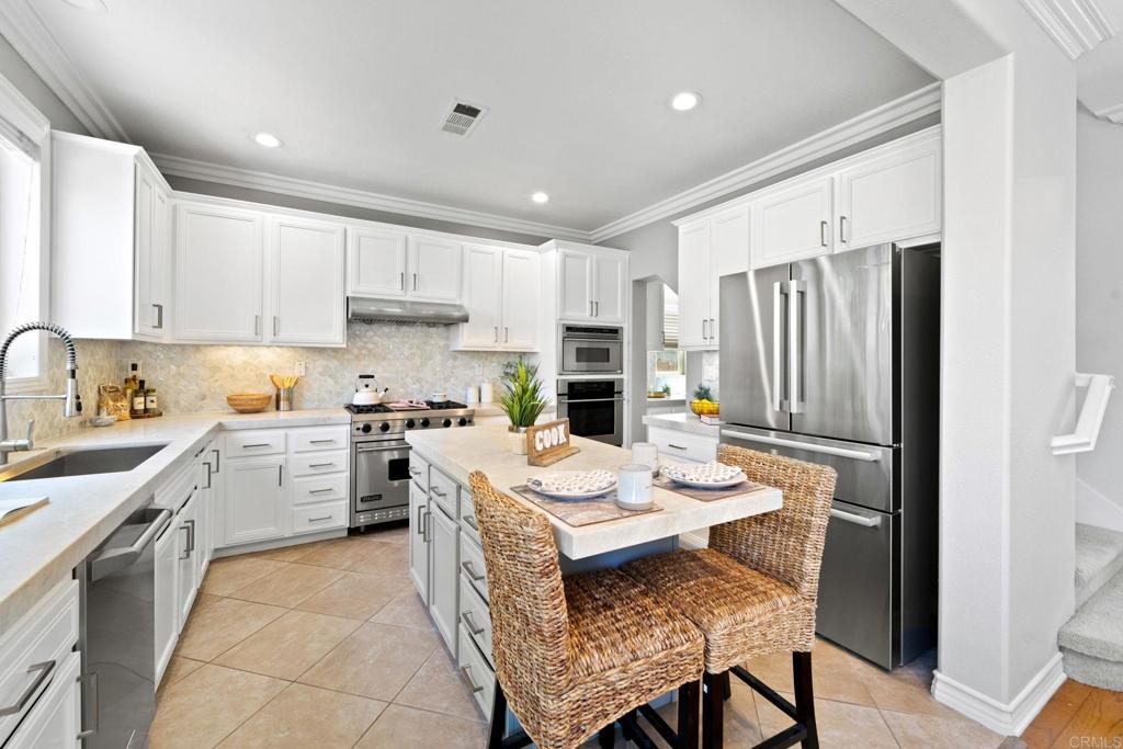 871 First Light Road San Marcos, CA 92078 - Photo 31 of 45 a kitchen with a refrigerator a stove a sink a dining table and chairs