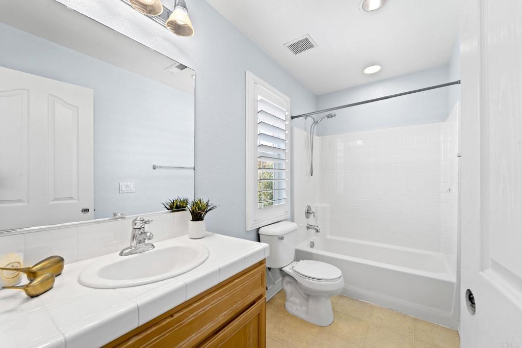 871 First Light Road San Marcos, CA 92078 - Photo 9 of 45 a bathroom with a granite countertop sink toilet a large mirror and shower