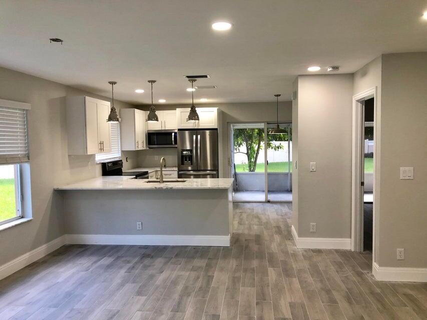 a view of kitchen with sink and refrigerator