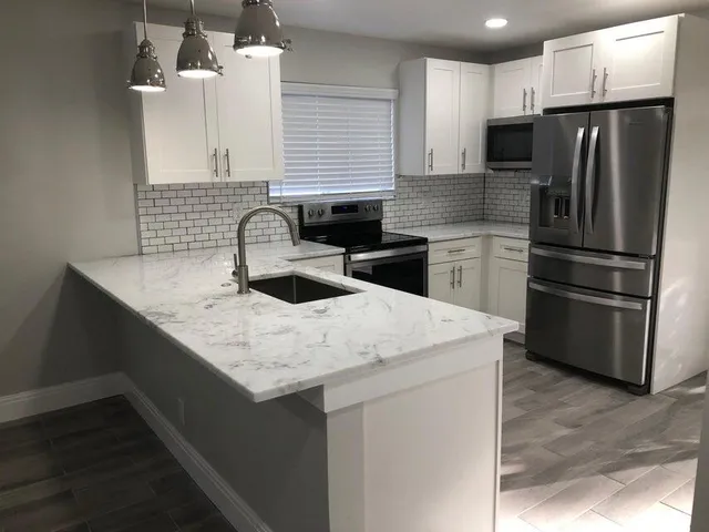 a kitchen with stainless steel appliances granite countertop a sink stove and refrigerator