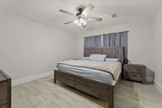 a bedroom with a bed and a ceiling fan