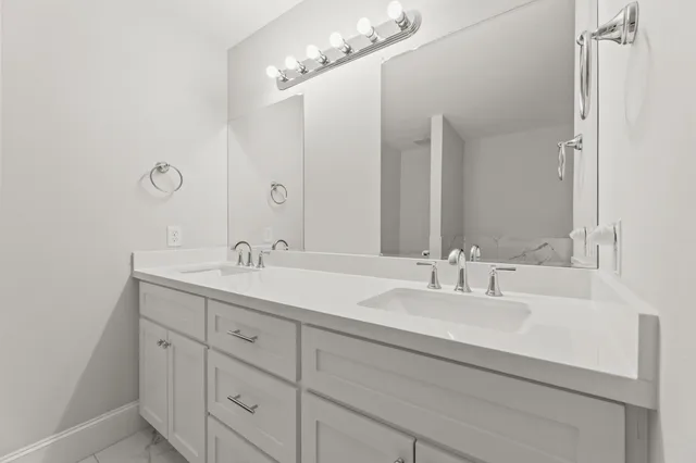 a bathroom with double vanity sinks and a mirror