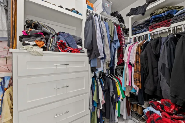 a view of walk in closet with clothes