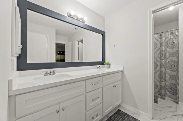 a bathroom with a double vanity sink and a mirror