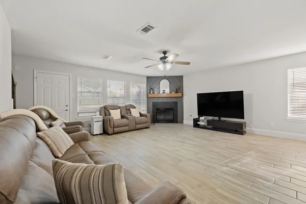 a living room with furniture a flat screen tv and a fireplace