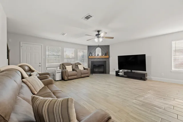 a living room with furniture a flat screen tv and a fireplace